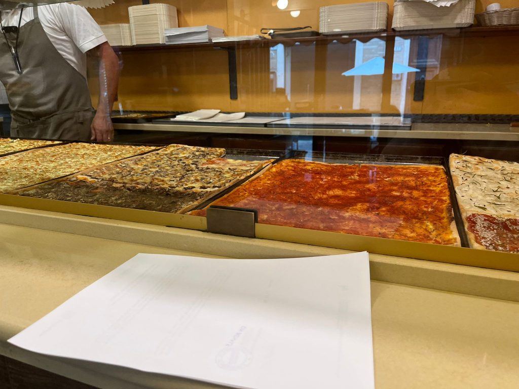 Photographie de la vitrine où sont exposés les différents goûts de pizza, de la pizzeria Scalette.